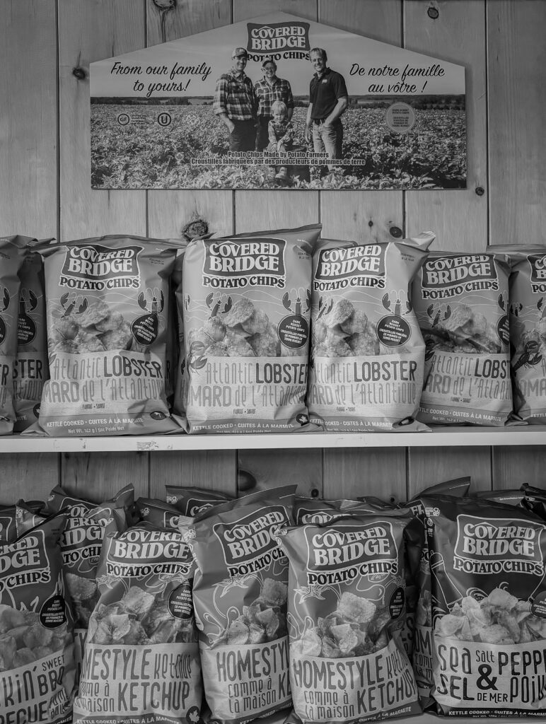 Two shelves containing Covered Bridge potato chips. 
