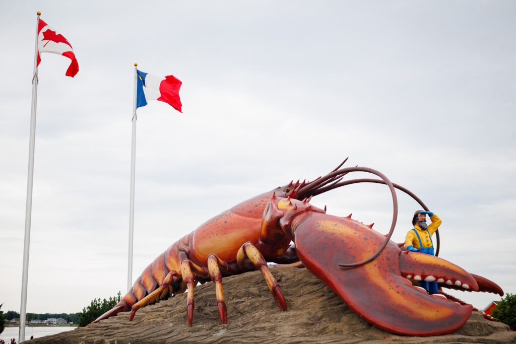 Large lobster statue with fisherman statue looking outwards. 