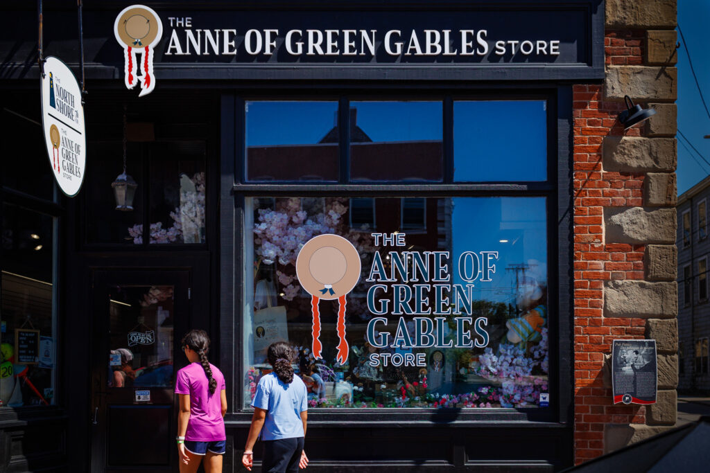 Two girls walking towards the door of the Anne of Green Gables storefront. 