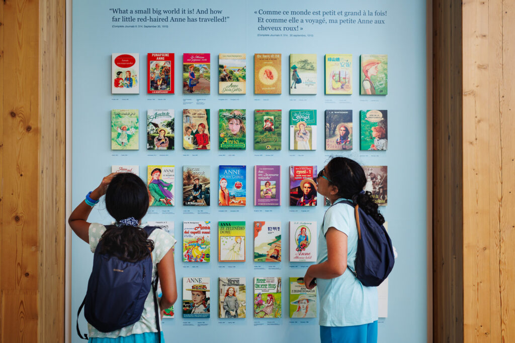 Two girls looking at display of Anne of Green Gables books translated into different languages. 