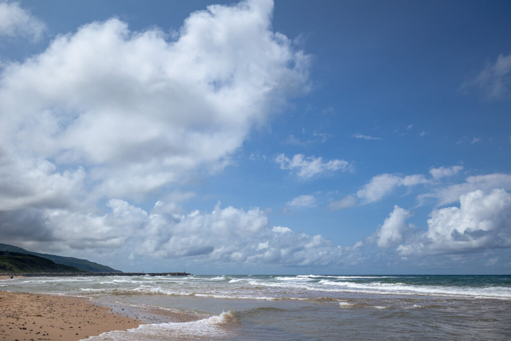 Skies filled with clouds on a coastline. 