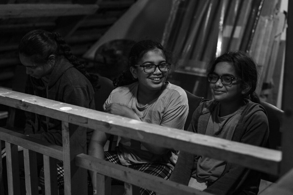 A girl smiling at her sister. 