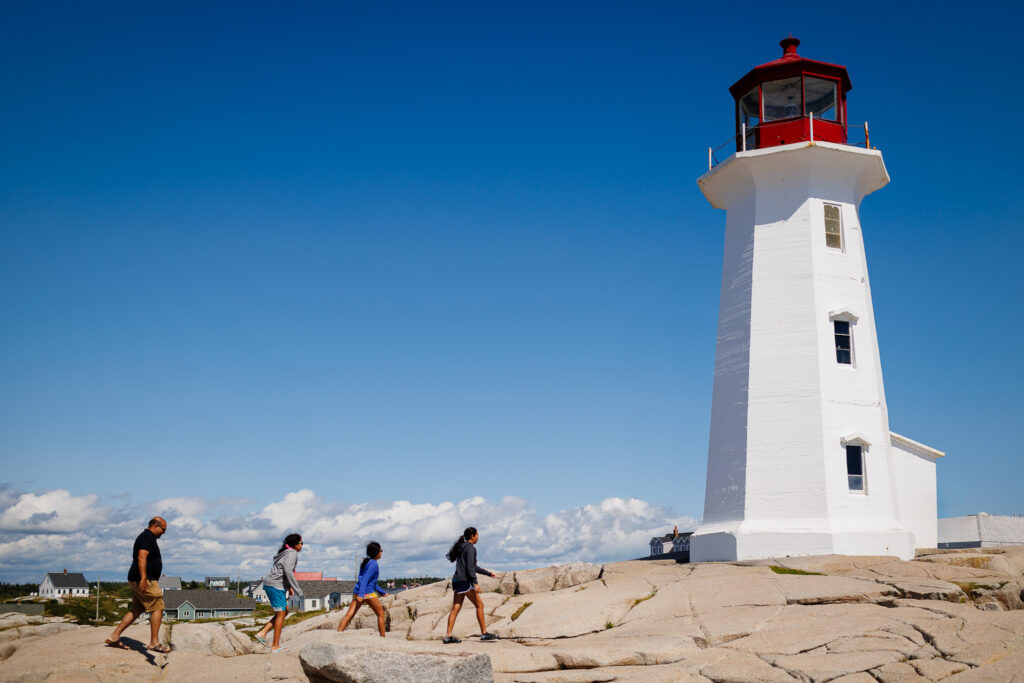 Girls walking towards Peggy Cove's lighthouse. 